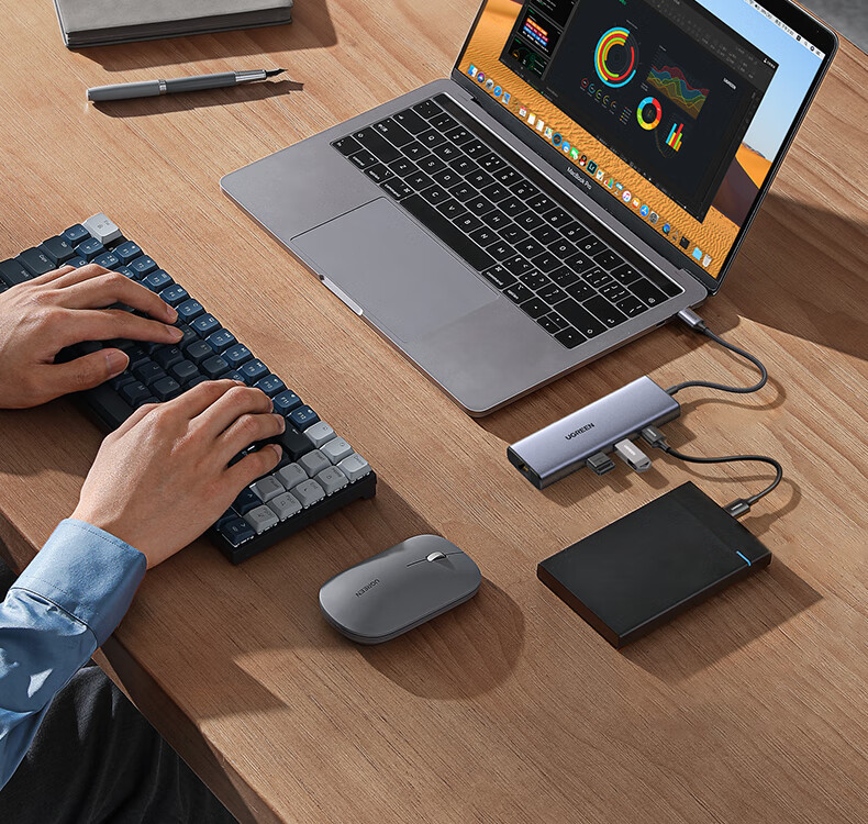 UGREEN CM512扩展坞与MacBook连接示意图，显示多功能扩展